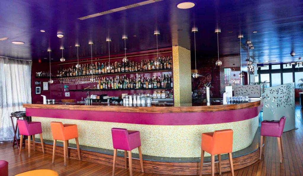 Atelier Cocktail Bar con taburetes multicolores en Bohemia Suites & Spa