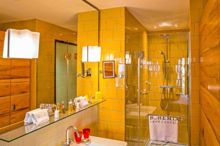 Habitación doble de lujo: baño moderno de estilo bohemio con lavabo, toallas, espejo, artículos de tocador y cabina de ducha de lluvia | Bohemia Suites & Spa