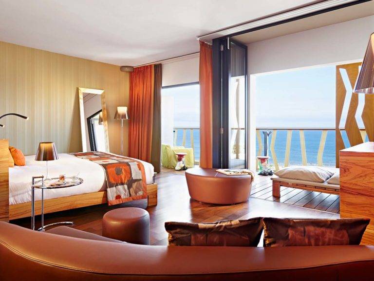 جناح جونيور - غرفة حديثة على الطراز البوهيمي مع سرير كينج ومنطقة جلوس وشرفة تطل على المحيط | أجنحة وسبا بوهيميا