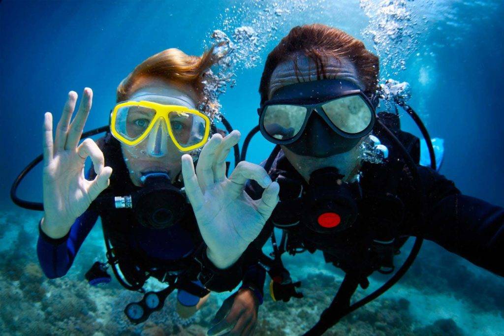 Pareja tomando un selfie bajo el agua mientras bucea en la costa de la isla de Gran Canaria
