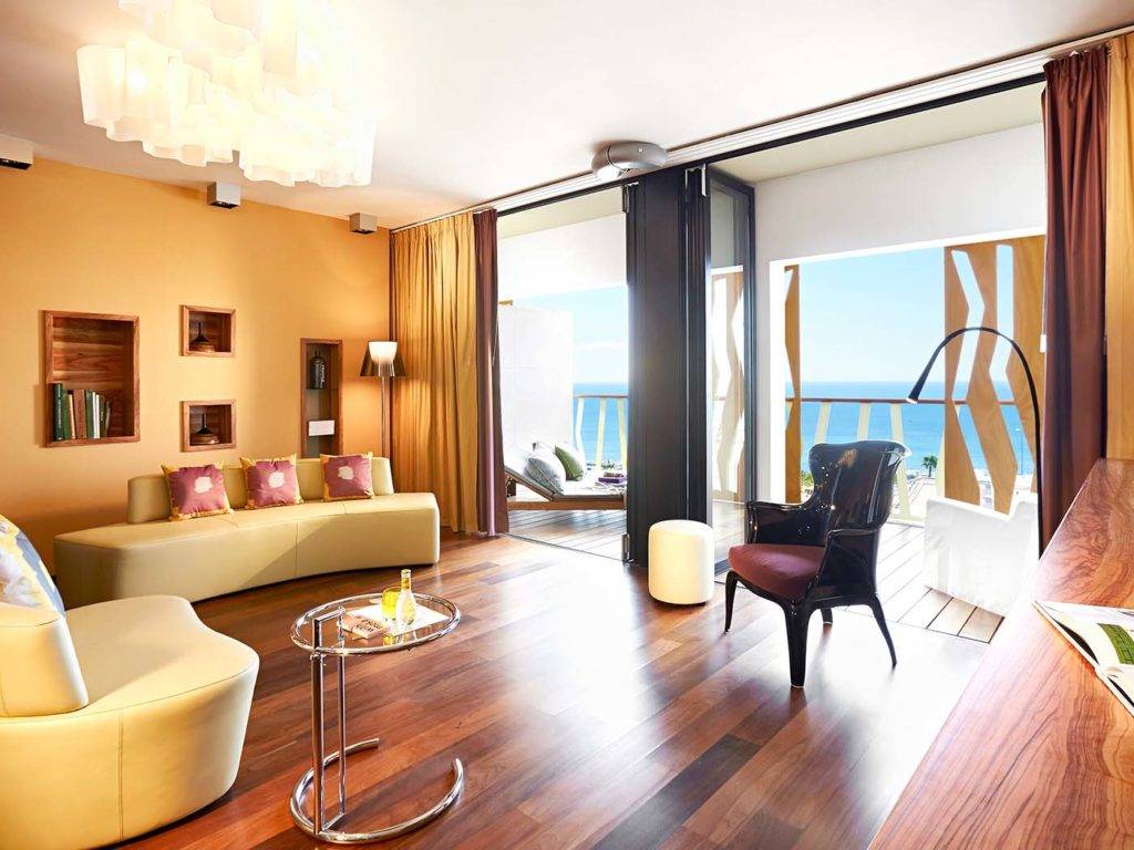 Sky Suite: sala de estar moderna de estilo bohemio con asientos cómodos, acceso al balcón y vista al mar | Bohemia Suites & Spa