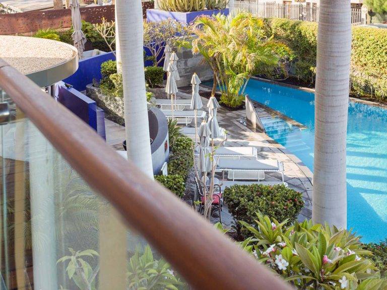 Studio Suite - Vista de la exuberante área de la piscina al aire libre desde el balcón | Bohemia Suites & Spa
