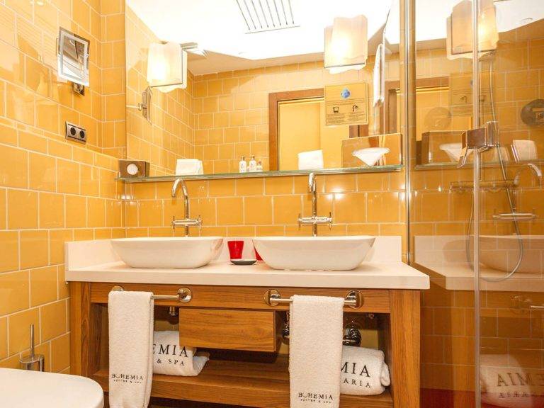Studio Suite modernes Badezimmer im böhmischen Stil mit Doppelwaschbecken, Toilettenartikeln und Spiegeln | Bohemia Suites & Spa