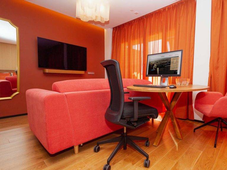Studio Suite moderna sala de estar de estilo bohemio con TV, asientos cómodos y estación de trabajo | Bohemia Suites & Spa