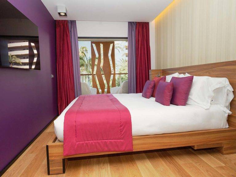 Studio Suite dormitorio moderno de estilo bohemio con cama queen, TV y acceso al balcón | Bohemia Suites & Spa