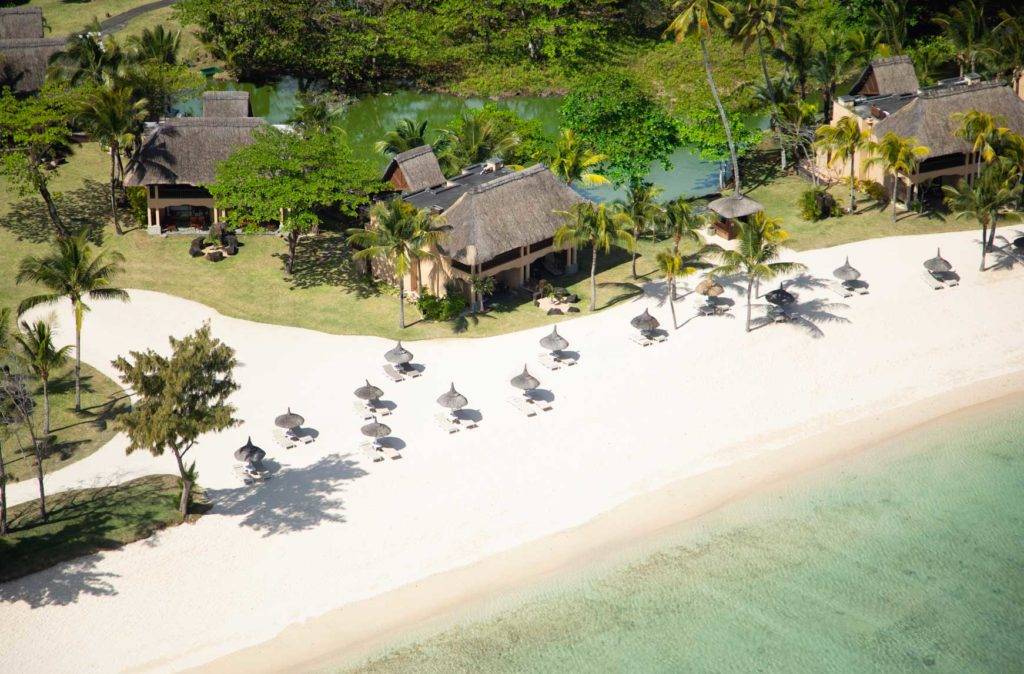 Vista aérea de la playa con tumbonas cubiertas con sombrillas en Shanti Maurice Resort & Spa