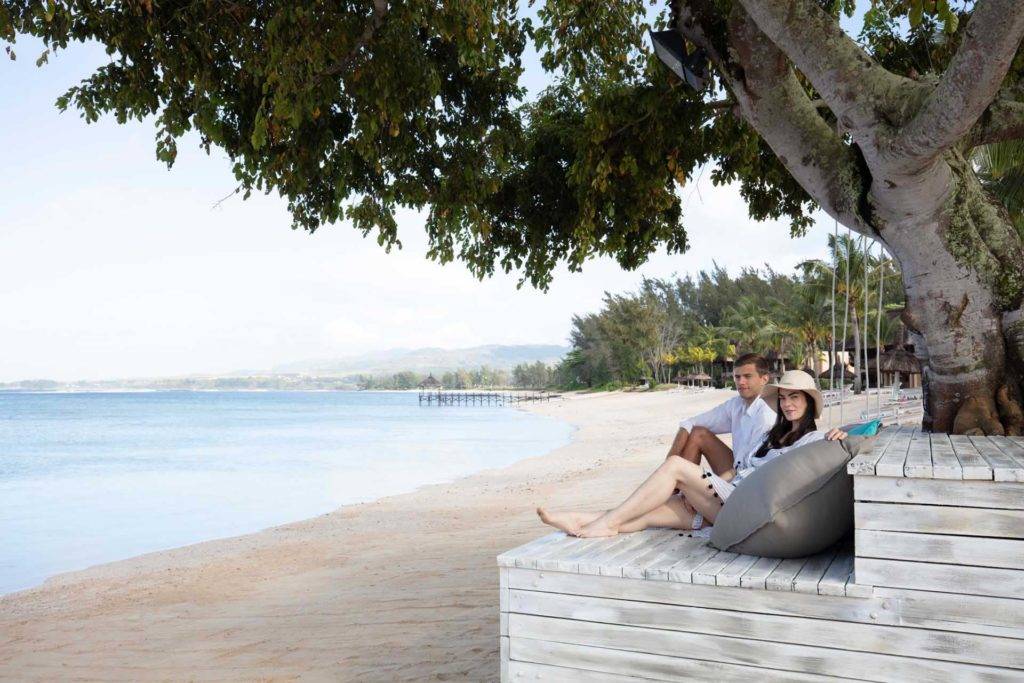 Pareja de relax en una tumbona de madera en la playa | Shanti Maurice Resort & Spa