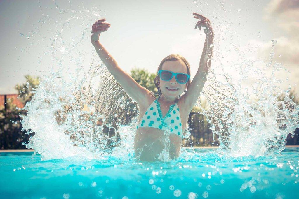 Niña con gafas de sol mientras chapoteaba en una piscina | Shanti Maurice Resort & Spa