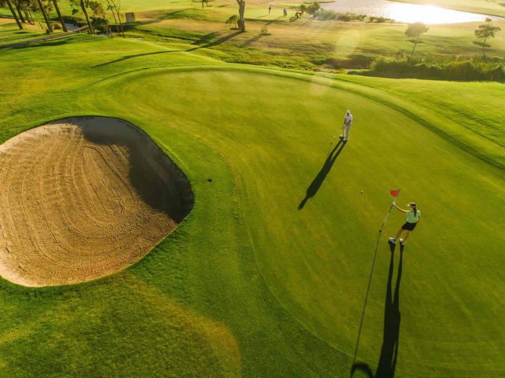 मॉरीशस में एक गोल्फ कोर्स पर गोल्फ का राउंड खेलते युगल का हवाई दृश्य