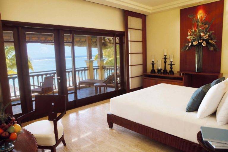 Suite Junior con vista a la laguna: habitación King con estación de trabajo, velas y puertas que conducen al balcón al aire libre | Shanti Maurice Resort & Spa