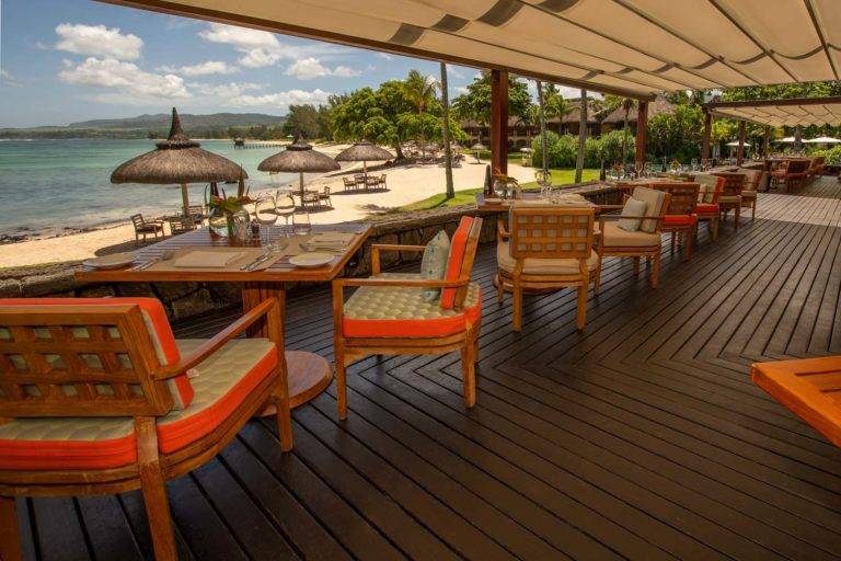 Patio al aire libre cubierto del restaurante Stars con mesas de restaurante y vista al mar | Shanti Maurice Resort & Spa