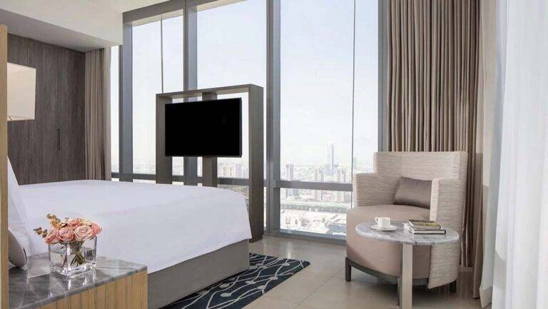 JVC Horizon Suite: habitación contemporánea con cama King, sala de estar, TV y ventanas grandes | Primer hotel de colección en JVC