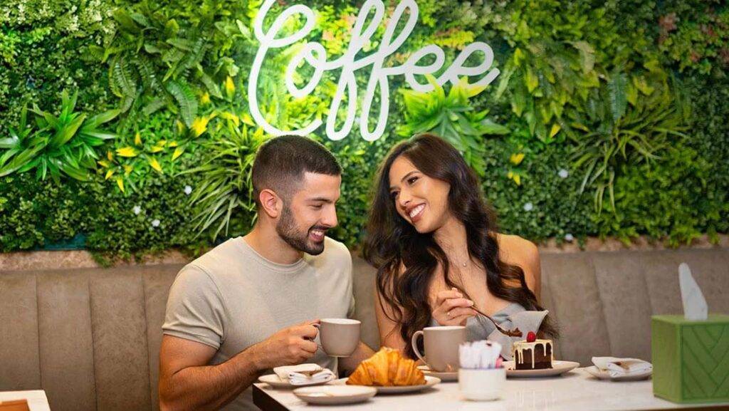 Paar sitzt an einem Tisch im Risen Café und genießt Kaffee und Gebäck | Erste Kollektion JVC Hotel