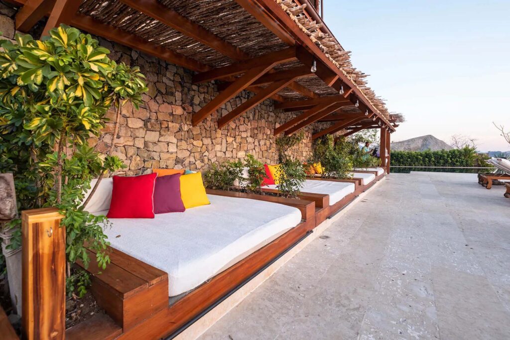 Tumbonas de gran tamaño con coloridos cojines en la terraza de la piscina | Casa Camaleón en Las Catalinas