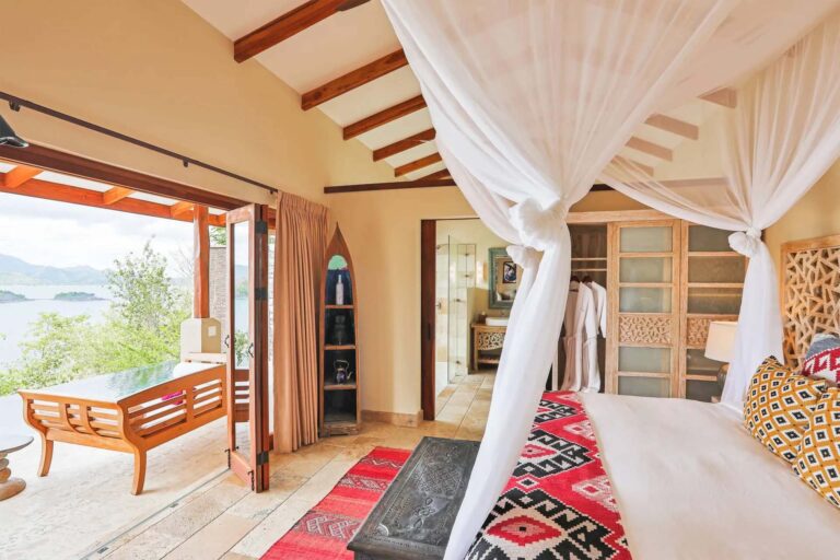 Villa con piscina de inmersión: dormitorio con madera natural, puertas corredizas plegables que dan al balcón | Casa Camaleón en Las Catalinas