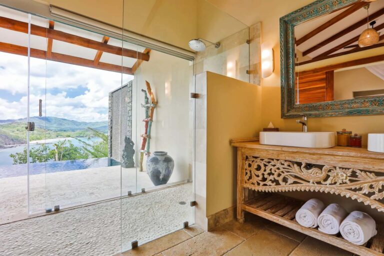 Villa con piscina de inmersión: baño con ducha interior/exterior con mampara de vidrio y tocador doble | Casa Camaleón en Las Catalinas