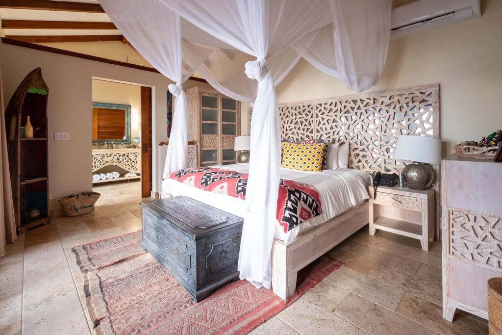 Villa con piscina de inmersión: cama King con dosel rodeada de muebles de inspiración costarricense con baño en suite | Casa Camaleón en Las Catalinas