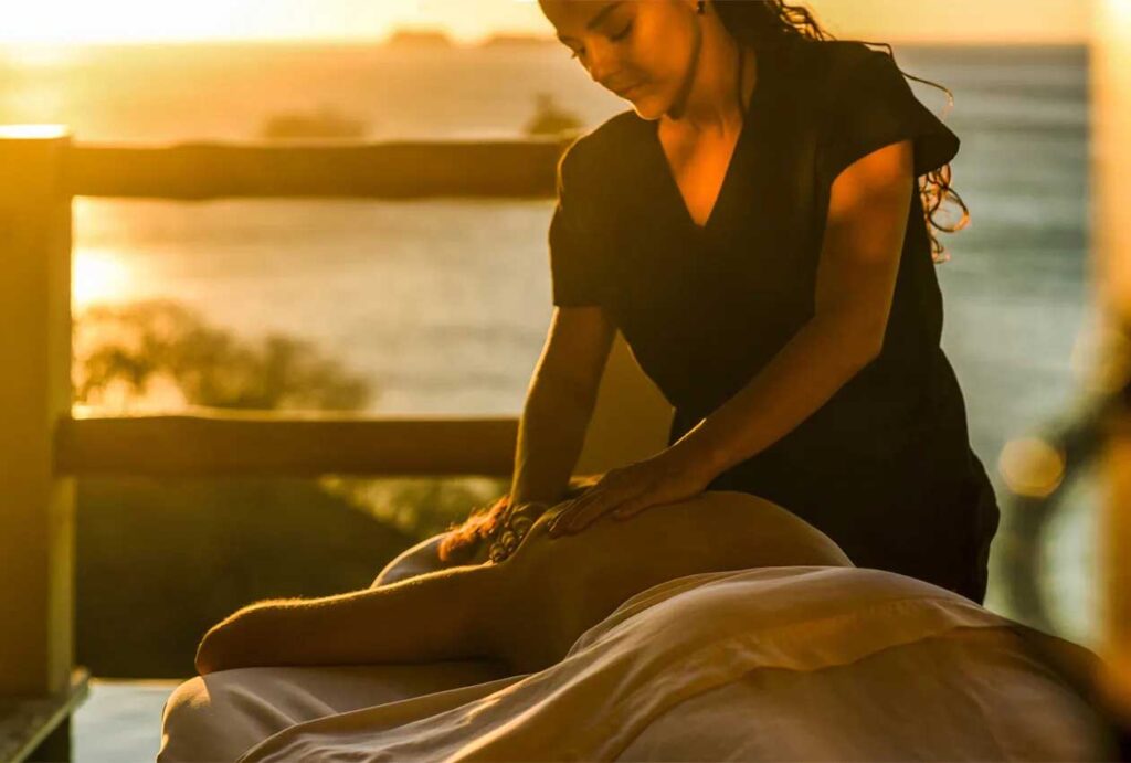 Mujer recibiendo un masaje de espalda en su villa privada al atardecer | Casa Camaleón Las Catalinas