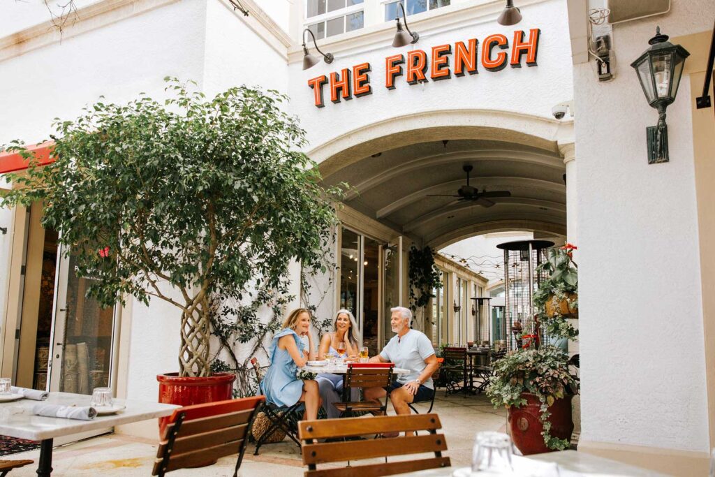 عائلة تستمتع بوجبة الجلوس خارج المطعم الفرنسي في نابولي ، فلوريدا