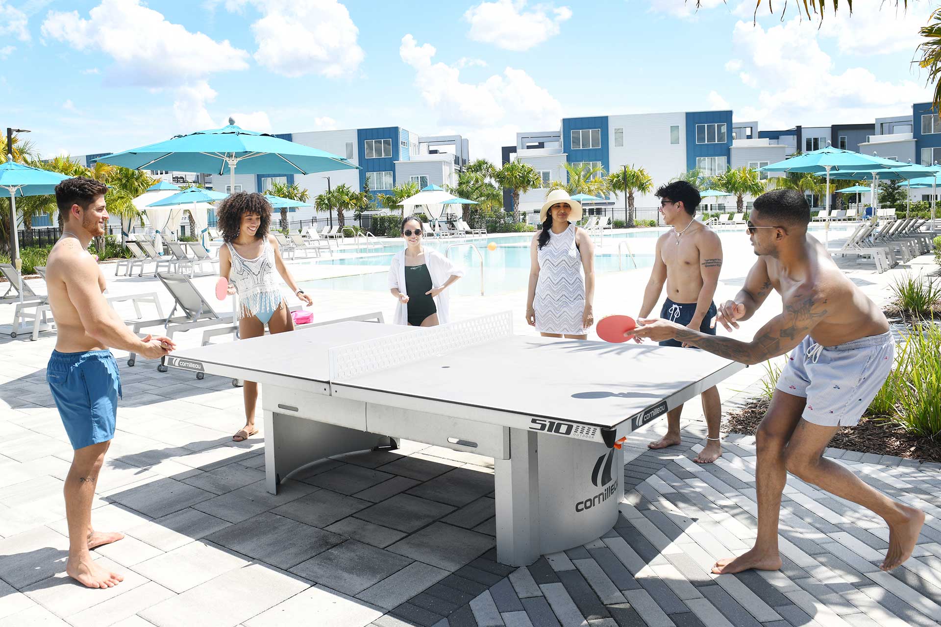 Grupo de amigos jugando un partido de ping pong en Spectrum Resort Orlando