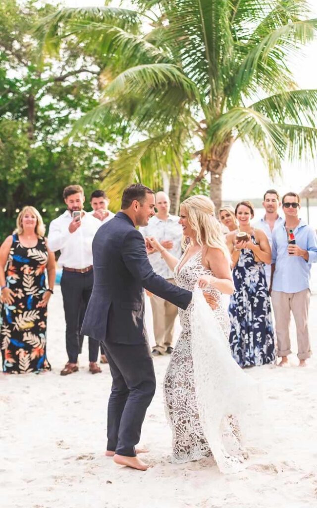 زوجان يؤديان رقصتهما الأولى في حفل زفافهما على الشاطئ أمام العائلة والأصدقاء | منتجع لارجو