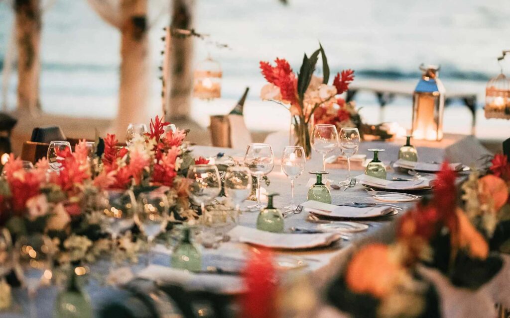 طاولة استقبال الزفاف مزينة بالزهور الاستوائية والفوانيس وإعدادات الأماكن | منتجع لارجو