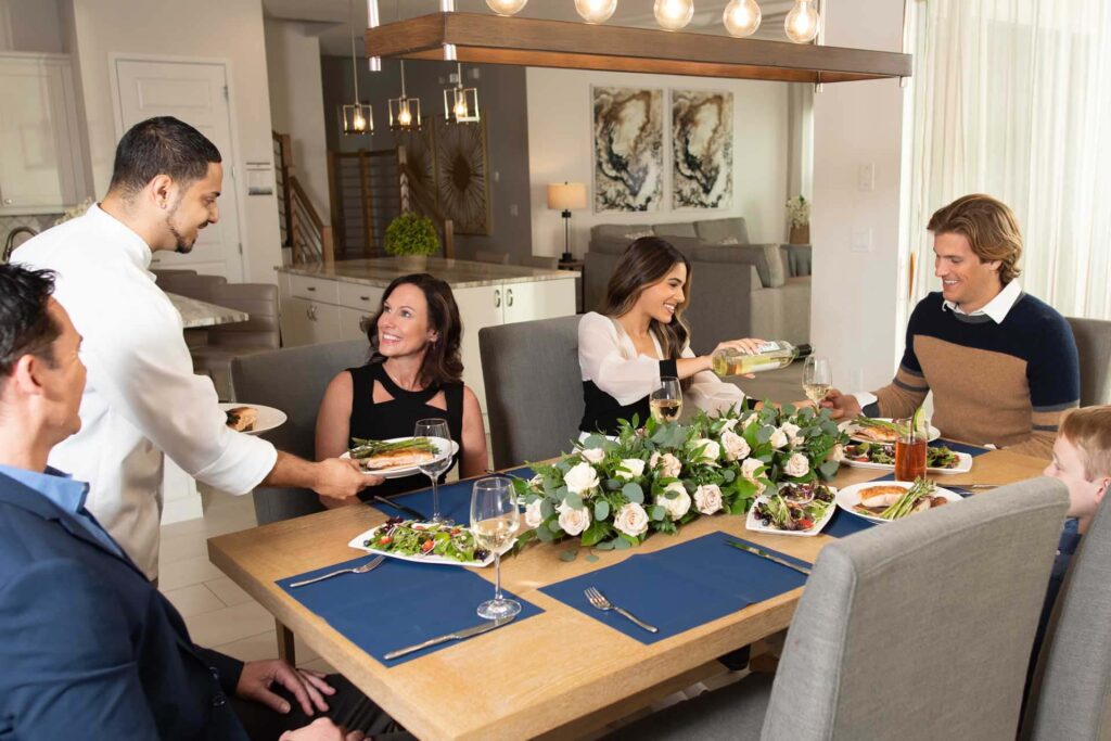 Familia a la que su chef privado sirve la cena en el comedor de su casa en Bear's Den Resort