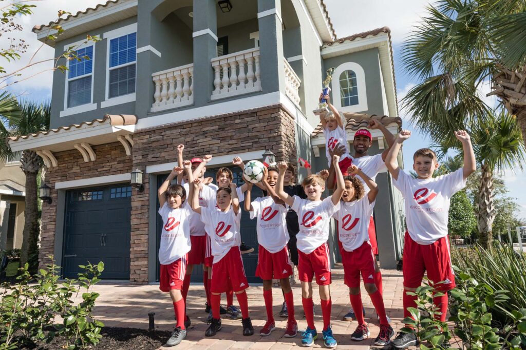 Encore Resort soccer team celebrating a win in front of their resort home