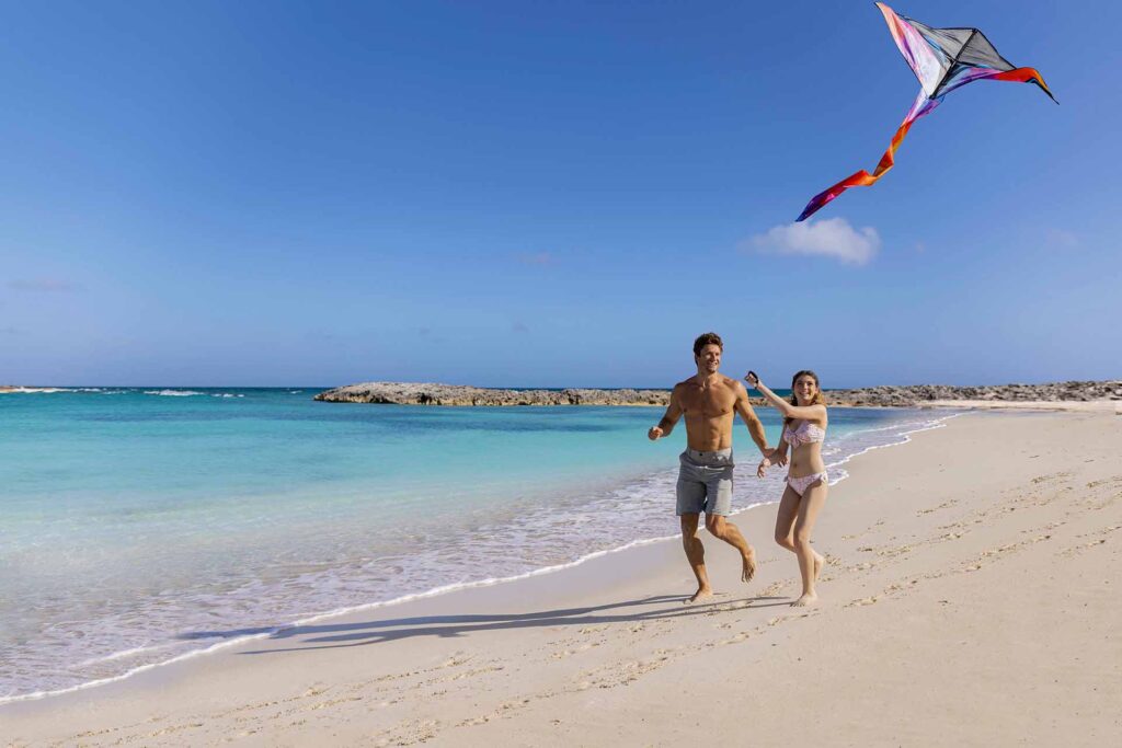 Father and daughter flying a kite on the beach
