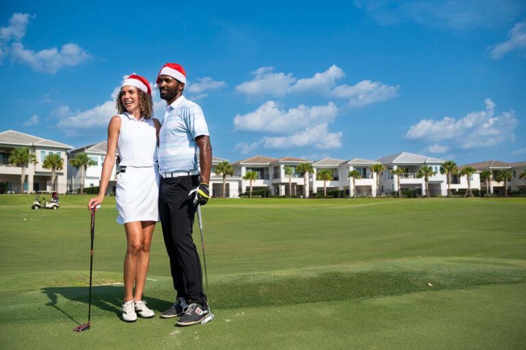 Couple sur un terrain de golf portant des chapeaux de Père Noël au Bear's Den Resort