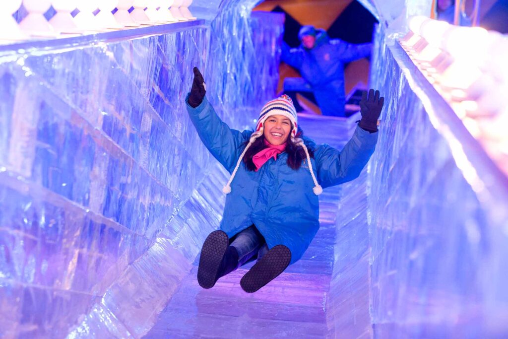 Niña deslizándose por un tobogán de hielo para el evento navideño ICE en el Gaylord Palms Resort
