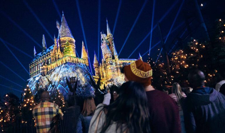 Couple admiring Hogwarts castle lit up with Christmas lights at Universal Orlando