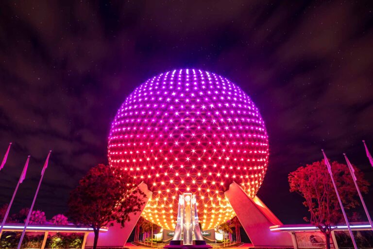 Spaceship Earth at EPCOT lit up with multicolors at night