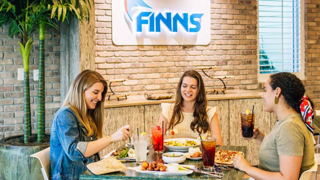 Glückliche Gruppe von Frauen essen zusammen im Finns Restaurant in Encore Resort