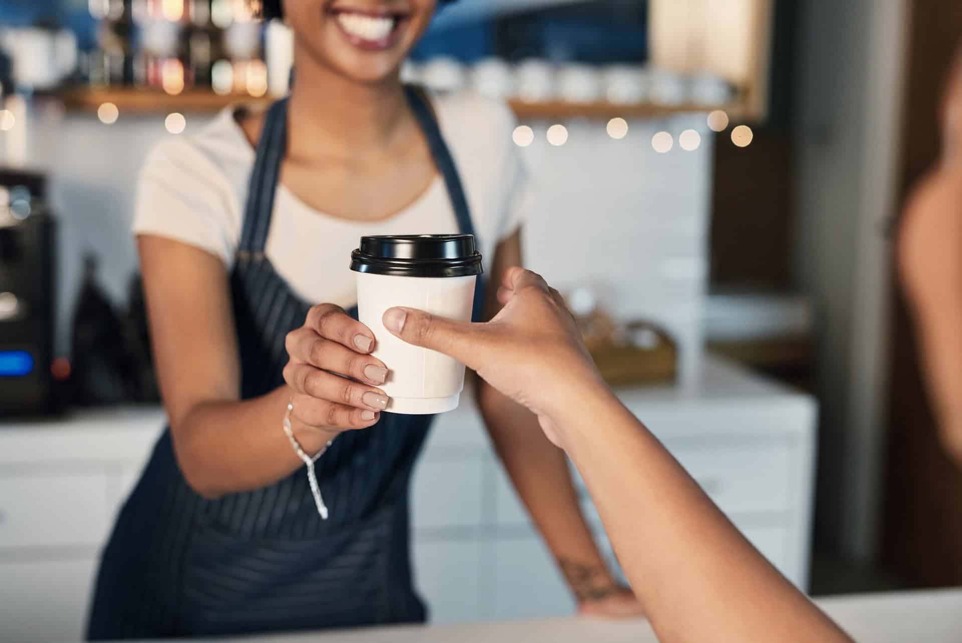Barista handing a customer a cup of coffee