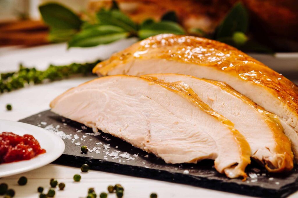 Slices of white meat Thanksgiving turkey on a black, stone plate