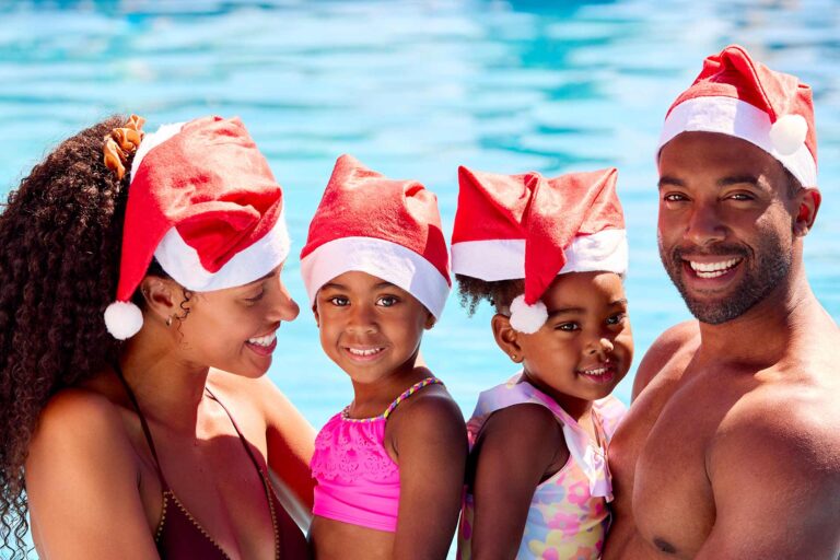 Happy family wearing Santa hats in a pool