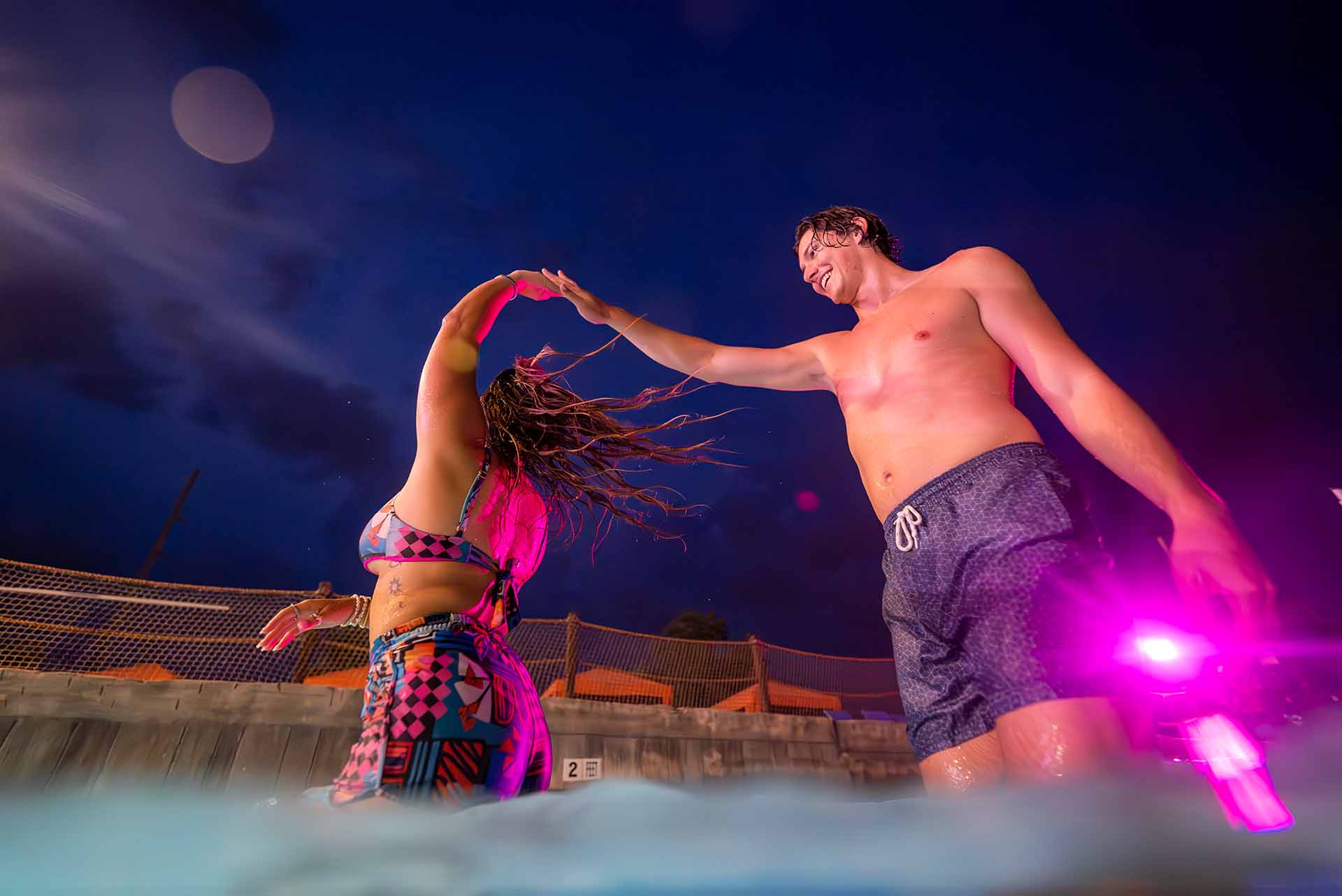 Couple dancing in a pool at night at Island H2O Water Park
