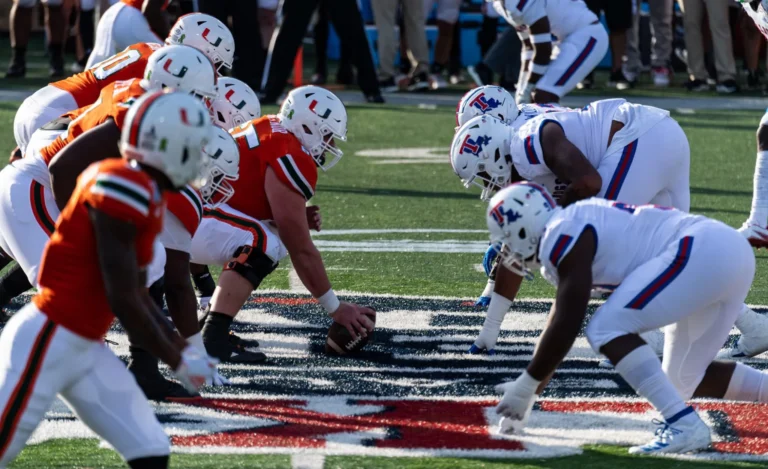 Opposing teams, the University of Miami football team (left), home of the Hurricanes, and the Louisiana Tech University football team (right), home of the Bulldogs, line up before the snap at the 2019 Walk-on’s Independence Bowl hosted at Independence Stadium in Shreveport, La., Dec. 26, 2019. (Wikimedia Commons/Airman 1st Class Lillian Miller)