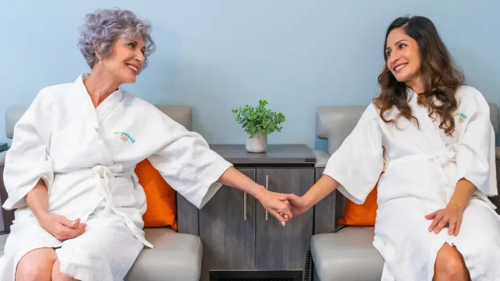 Mother and adult daughter holding hands during a St. Somewhere Spa service at Margaritaville Resort Orlando