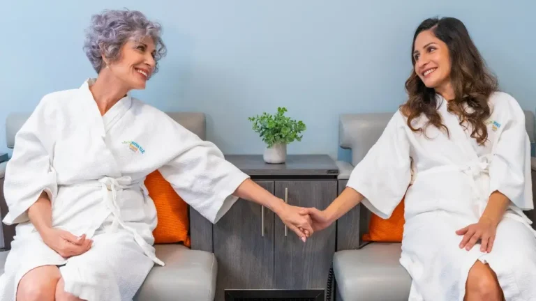 Mother and adult daughter holding hands during a St. Somewhere Spa service at Margaritaville Resort Orlando
